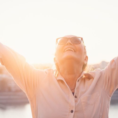 senior_woman_embracing_the_sky_and_sun-1343520623